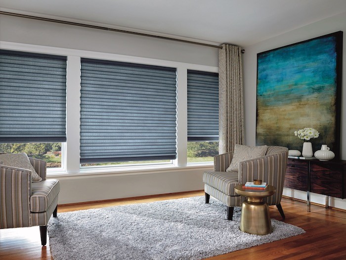 A living room with blue furnishings and a brass side table.